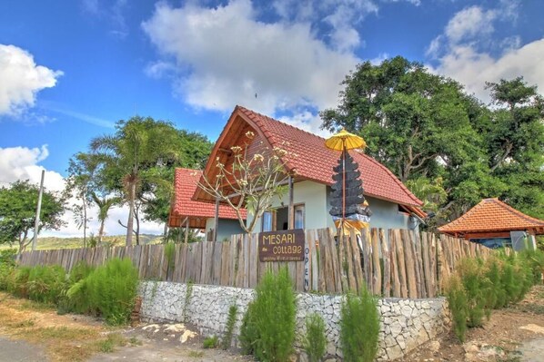 Ein rustikales Cottage mit Steinmauer und Holzzaun.