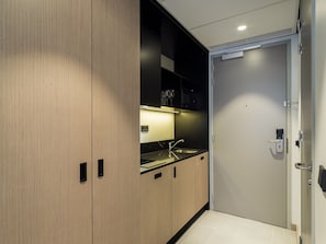 Une cuisine moderne équipée d’un évier, de placards et d’une porte avec une poignée.