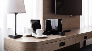 A hotel room with a wooden desk, a flat-screen TV, a lamp, and a coffee maker. - Executive Residency by Best Western Amsterdam Airport (Hoofddorp)