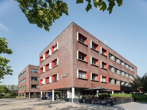 A multi-story building with a brick facade, large windows, and a sign indicating it is a hotel. - Executive Residency by Best Western Amsterdam Airport (Hoofddorp)
