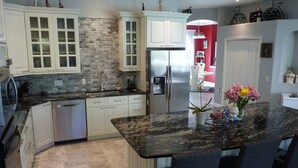 A modern kitchen with white cabinets, a granite countertop, and a stainless steel refrigerator. - Beautiful home on an 18 holes golf course (Sarasota)