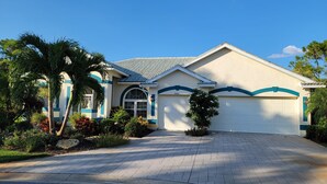 A two-story house with a driveway leading to a garage. - Beautiful home on an 18 holes golf course (Sarasota)