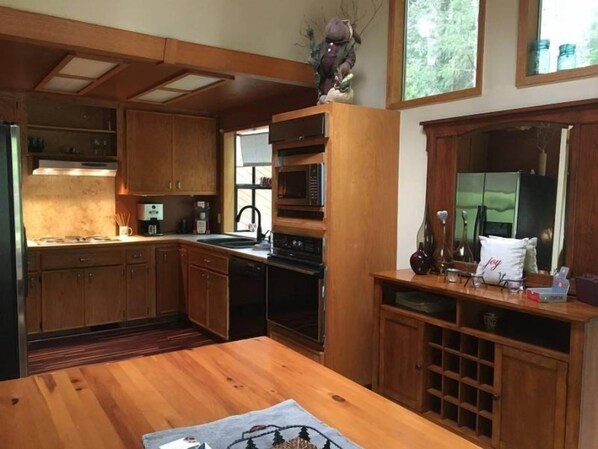 A kitchen with wooden cabinets, a microwave, and a sink.