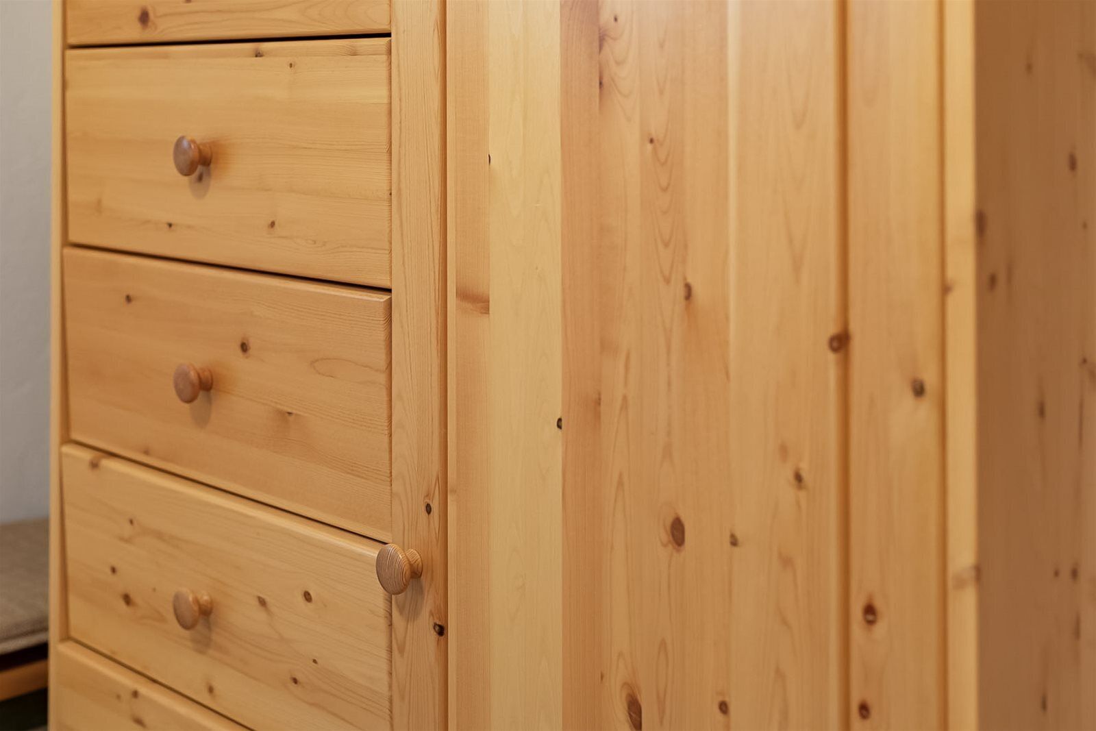 A wooden dresser with multiple drawers and knobs.