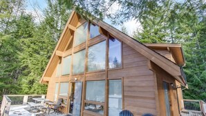 A wooden cabin with large windows, a deck, and two Adirondack chairs. - Trails End (Packwood)