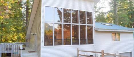 A modern, single-story building with large windows and a wooden deck.