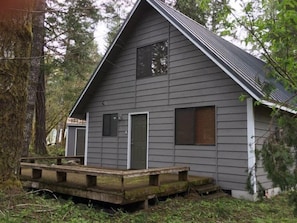 A small, single-story cabin with a gabled roof, a front door, and a small porch area.