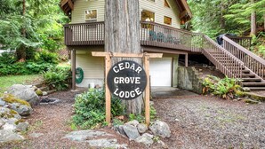 Eine Lodge mit Holzfassade, einer Veranda und einer Treppe zu einer Terrasse.