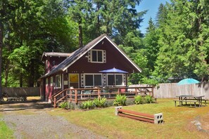 Een rustieke chalet met een veranda en zitplaats buiten.