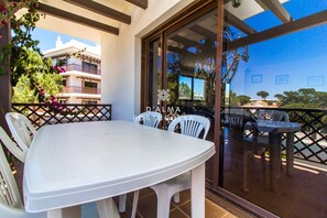 Guests can dine or socialize in this patio area, surrounded by a wooden pergola and offering a view of the surrounding environment.