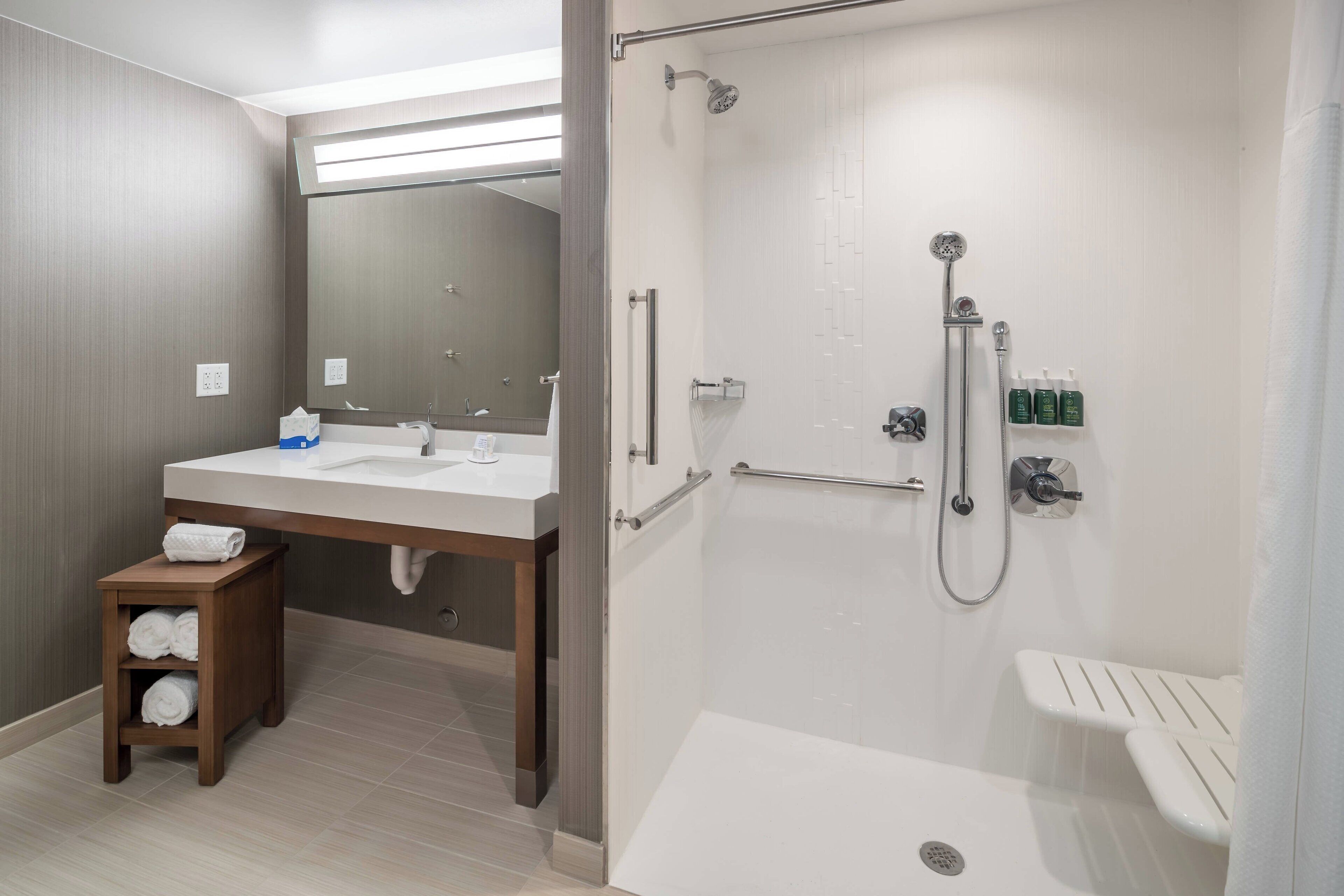 Een moderne badkamer met een douche, wastafel en toilet.