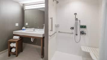 A modern bathroom with a shower, sink, and toilet.