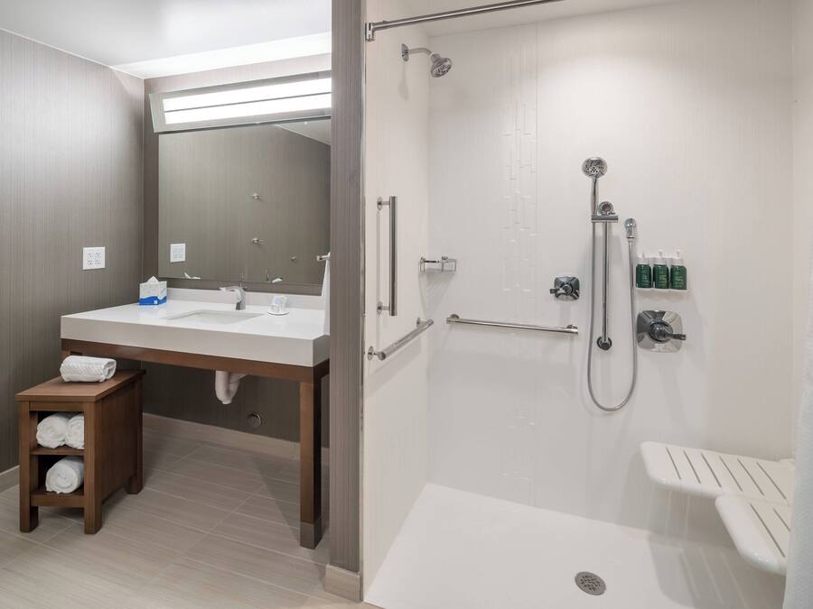A modern bathroom with a shower, sink, and toilet.