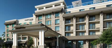 A multi-story hotel with a covered entrance, large windows, and a prominent 'Courtyard' sign.