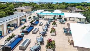 A rooftop patio with outdoor seating, a pool, and a view of the ocean. - Courtyard by Marriott Hilton Head Island (Hilton Head Island)