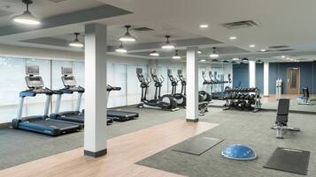 A gym with treadmills, elliptical machines, and free weights.