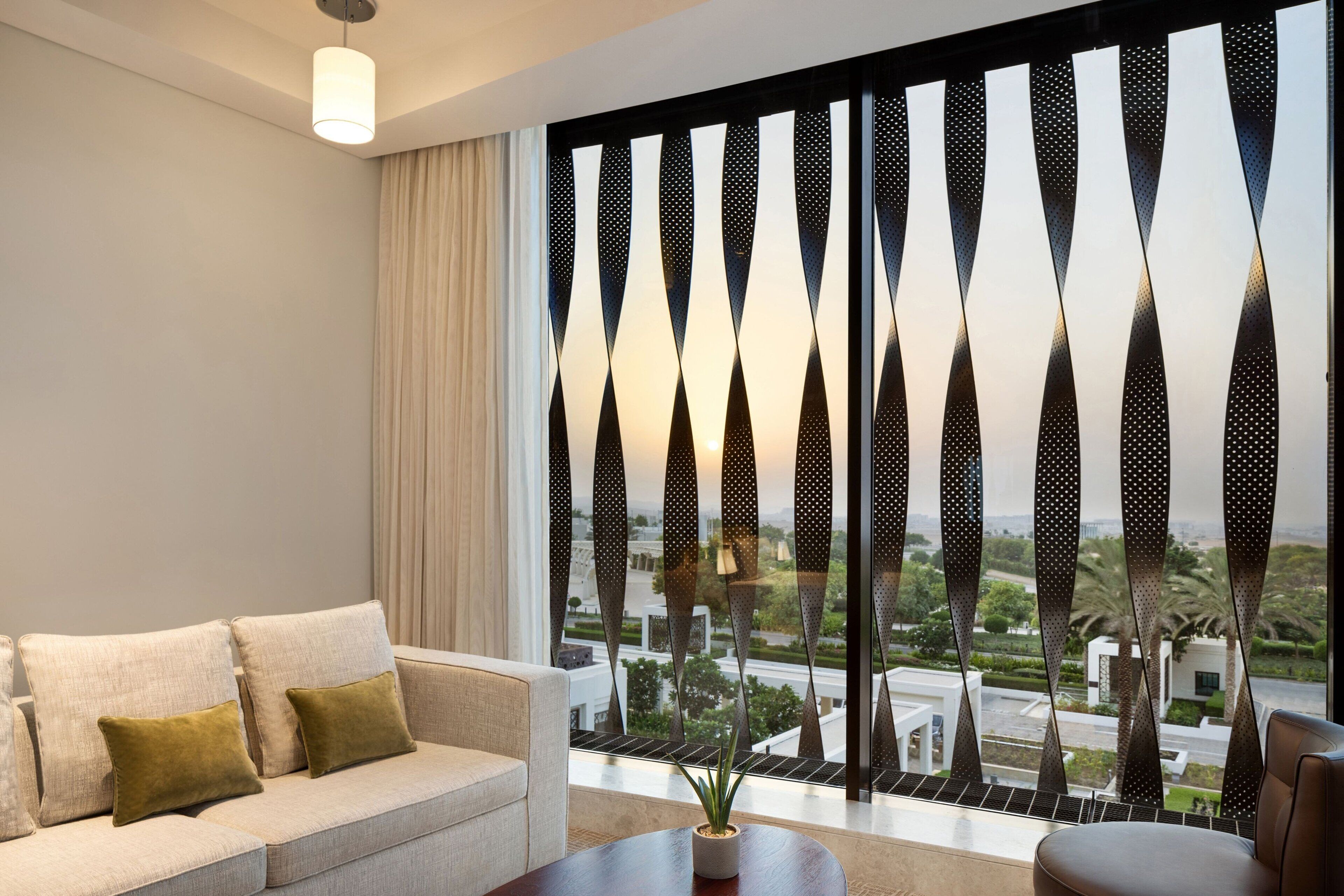 Un soggiorno moderno con un divano, un tavolino e una vista attraverso una finestra decorata.