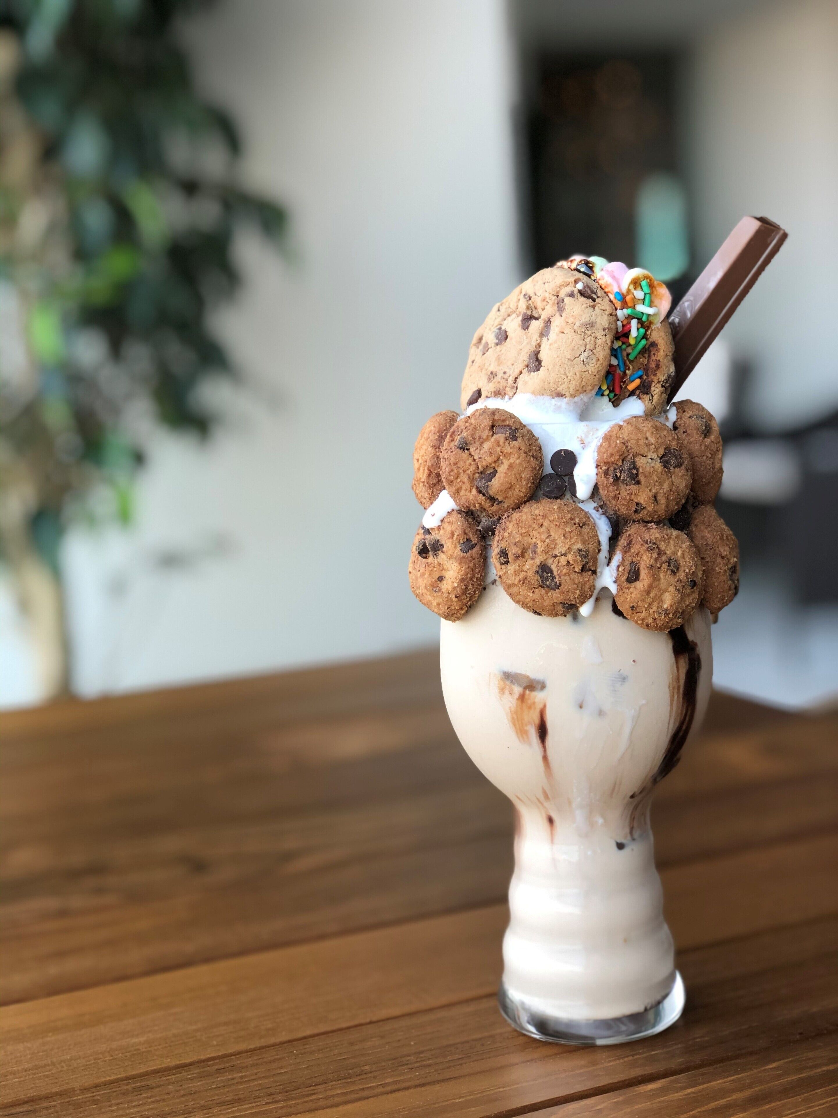 A dessert with cookies and sprinkles on a white cup.