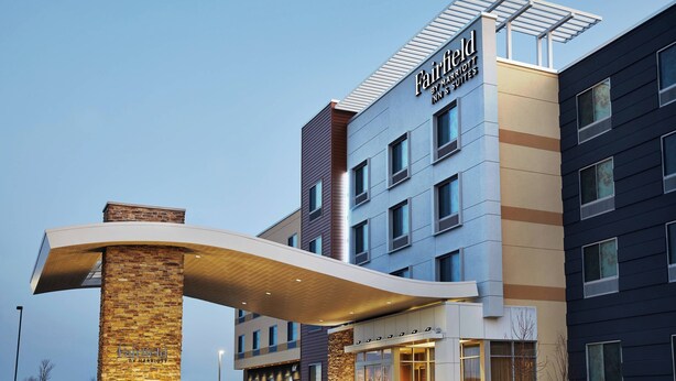 A modern hotel entrance with a curved canopy, multiple floors, and a prominent sign. - Fairfield Inn & Suites by Marriott Sheboygan (Sheboygan)