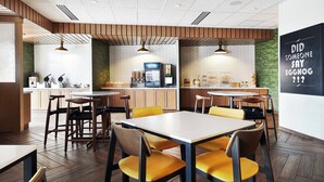 A modern restaurant with wooden accents, white tiled walls, and yellow chairs. - Fairfield Inn & Suites by Marriott Sheboygan (Sheboygan)