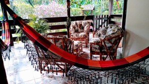Silla hamaca sobre un piso de baldosas, con vista a un jardín.