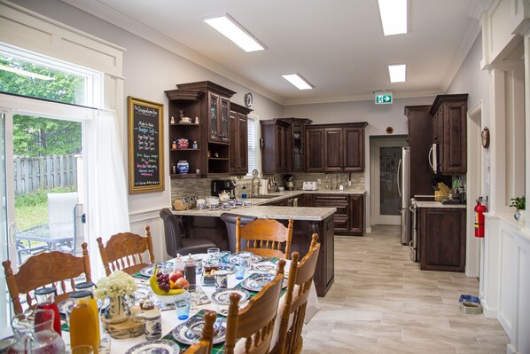 A kitchen with dark wooden cabinets, a central island, and a dining table set for six.