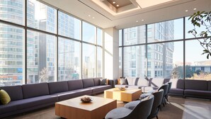 A modern interior with large windows, a sectional sofa, and a coffee table.