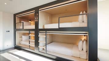 Un dormitorio moderno con literas de varios niveles, estanterías integradas y un diseño minimalista.