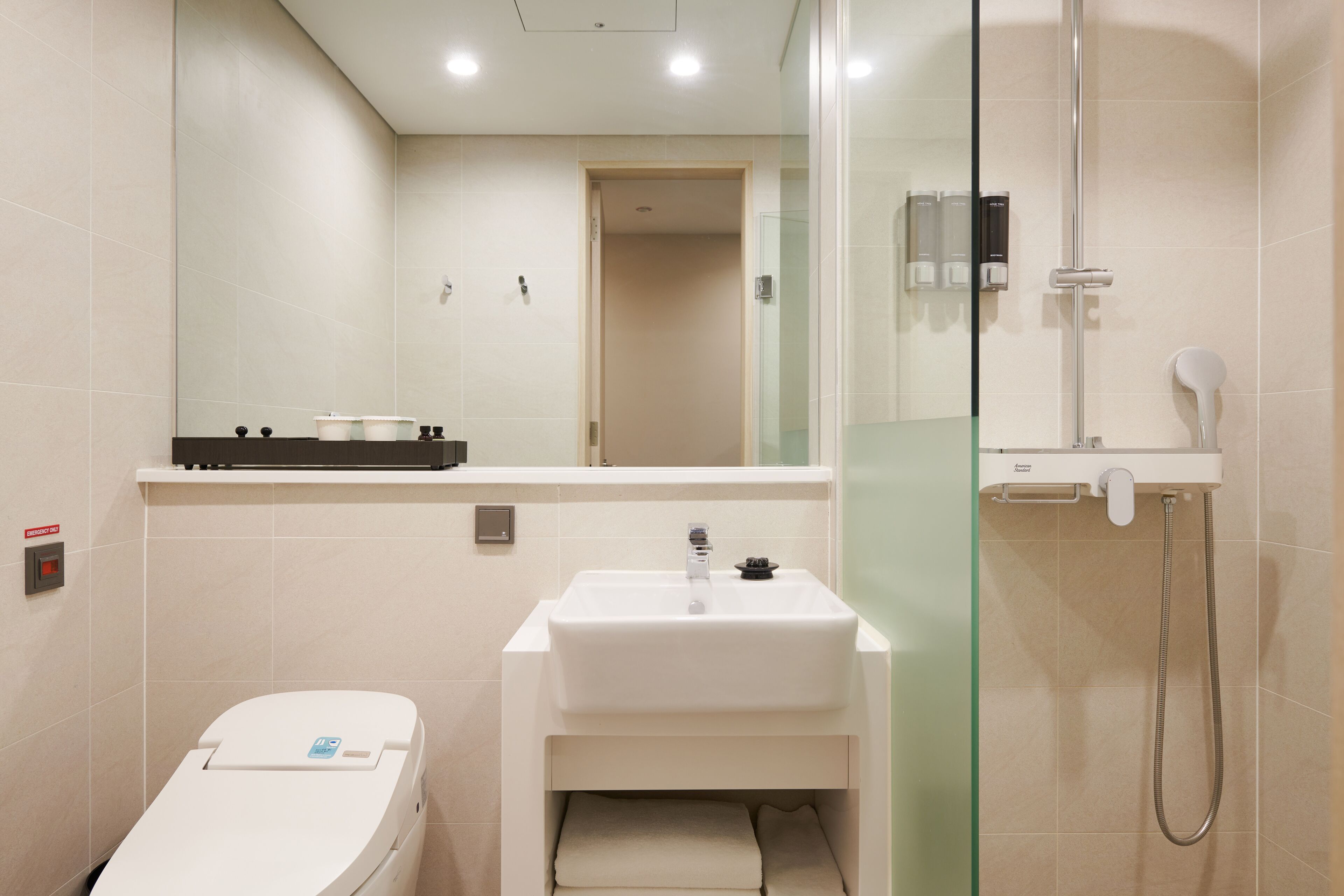Un baño moderno con inodoro, lavamanos y ducha.