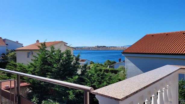 A coastal residential area with houses, a clear blue sea, and a staircase leading to a balcony. - Apartment Adriana 1 for 4 people (Omisalj)