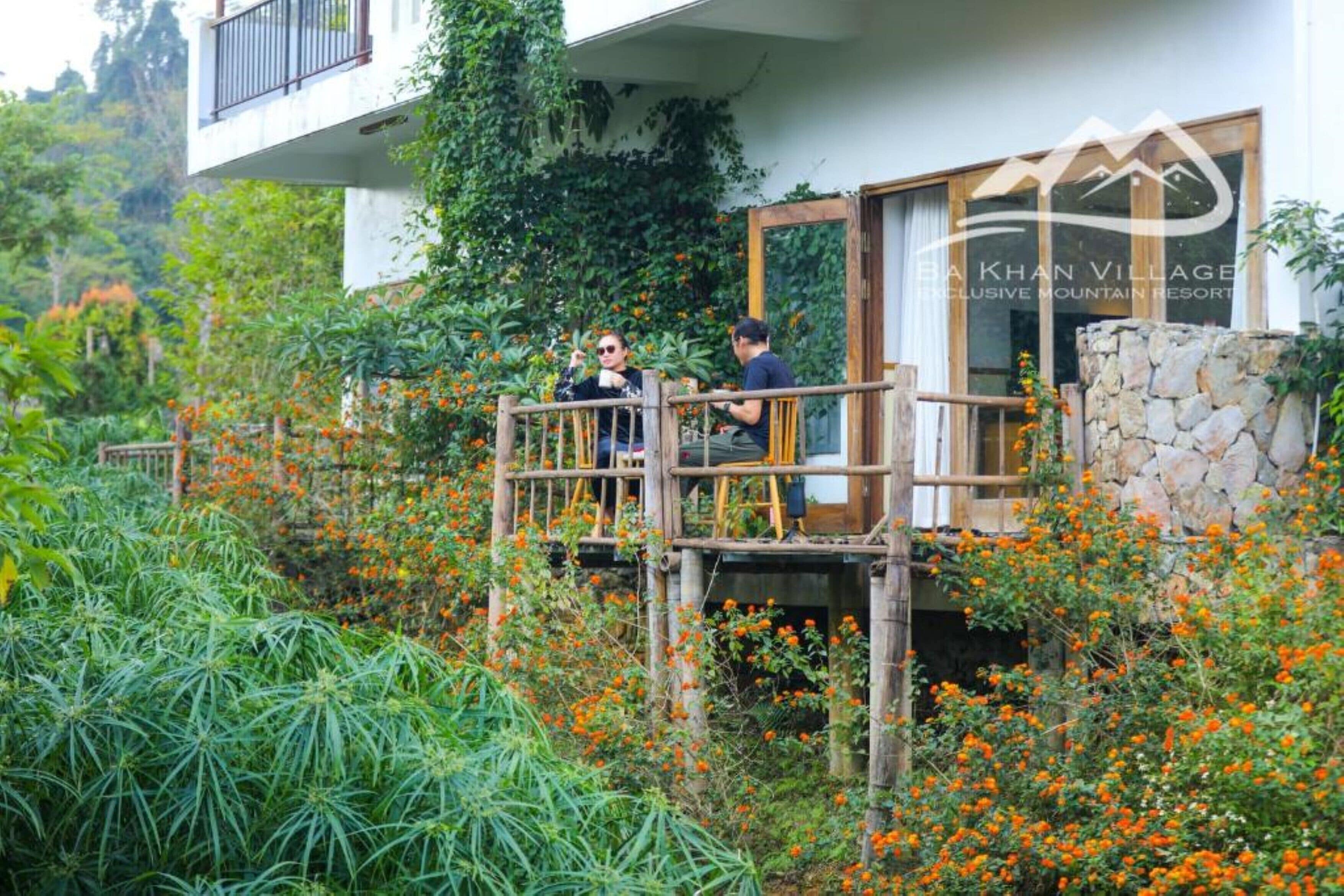 A wooden deck with a stone wall and a building with a balcony.