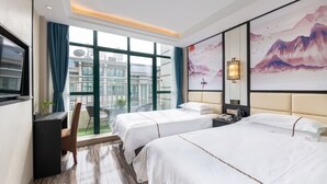 A hotel room with two beds, a desk, a chair, a large window with a view of buildings, and a wall-mounted TV. - Yiwu Luck Bear Hotel (Jinhua)