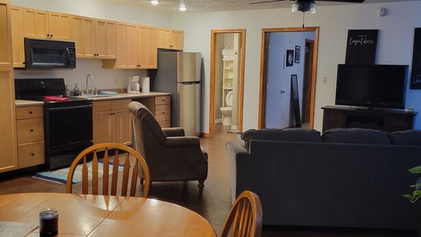 A compact living space with a kitchen, dining area, and seating area. - Shaggy Moos Apartment  (Bloomfield)