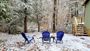 A snowy outdoor area with three blue chairs and a wooden staircase. - Escape on the river (French Creek)