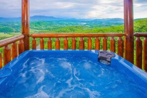 A hot tub with a wooden railing and a scenic view of green hills. - Stunning View | Hot Tub & Resort Pool Access (Sevierville)