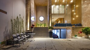 A hotel lobby with a reception desk, seating area, and a staircase leading to upper floors. - Sunkiss Hotel (Nha Trang)