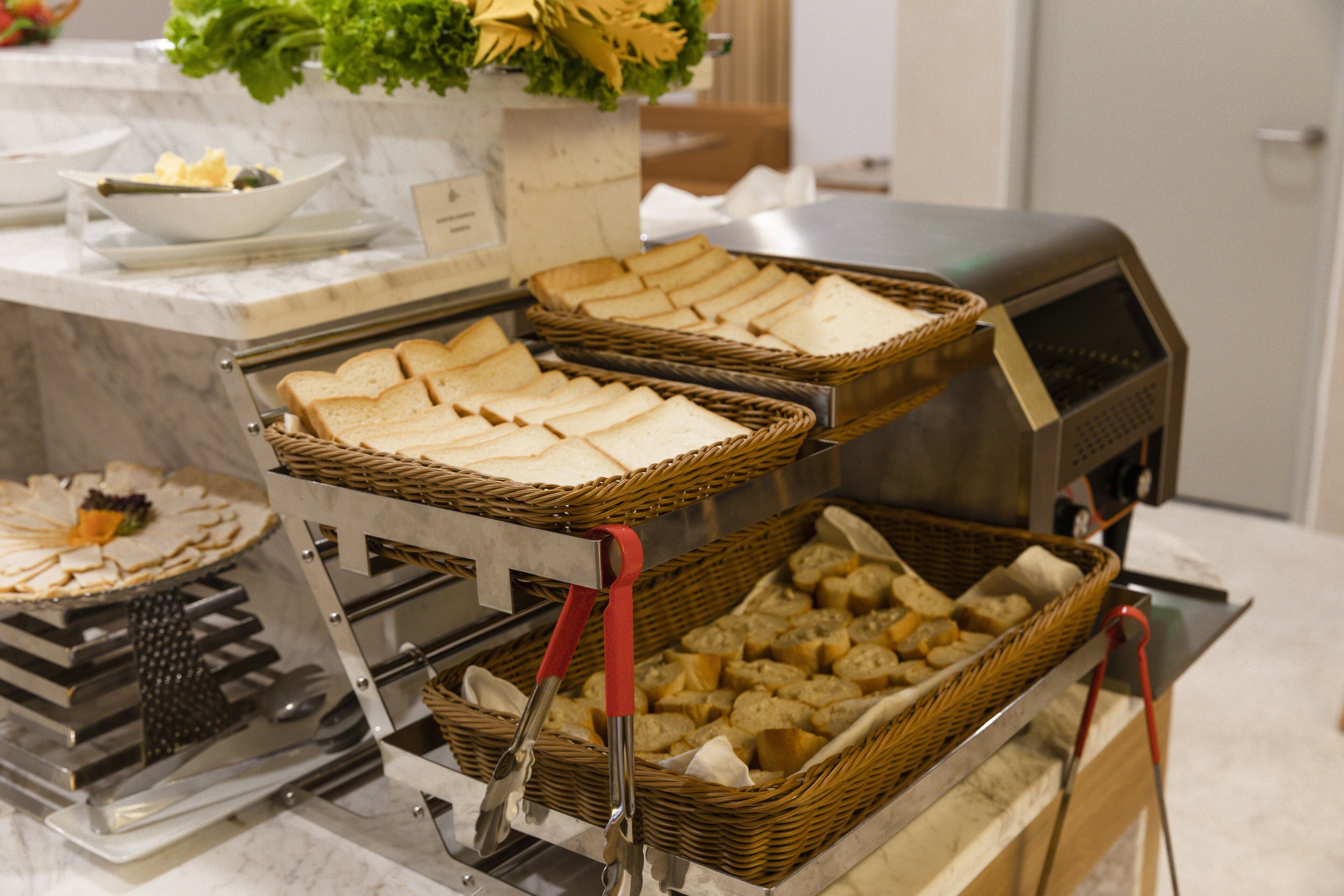 A buffet setup with multiple baskets of bread and other food items.