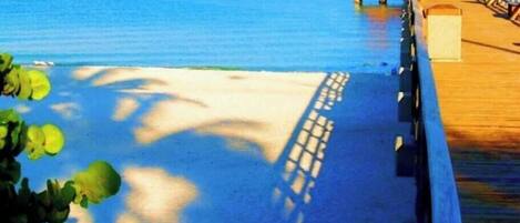 A pier extending into a calm sea with a clear sky.