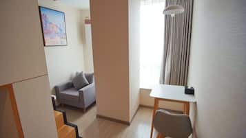Una sala de estar moderna con un sofá, una mesa de comedor y una escalera que lleva a otra habitación.