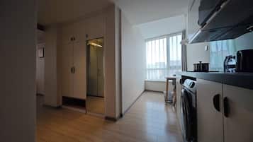 Una cocina moderna con horno empotrado, microondas y pileta. Se puede apreciar una ventana que proporciona luz natural y vistas a la ciudad.