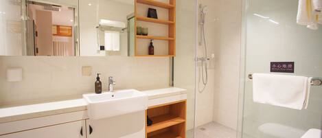 A modern bathroom with a glass shower enclosure, a white sink, and a wooden shelf unit.