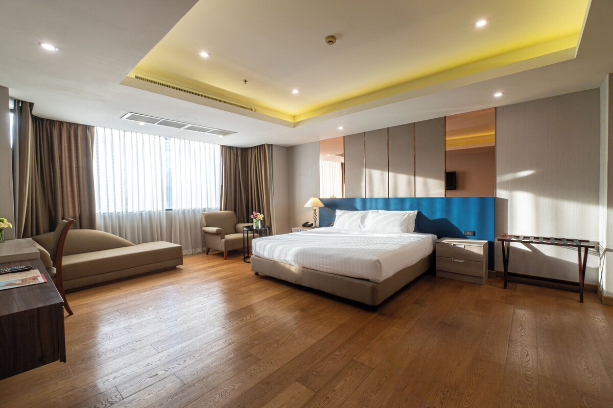 Een moderne hotelkamer met een groot bed, een bureau en een stoel.