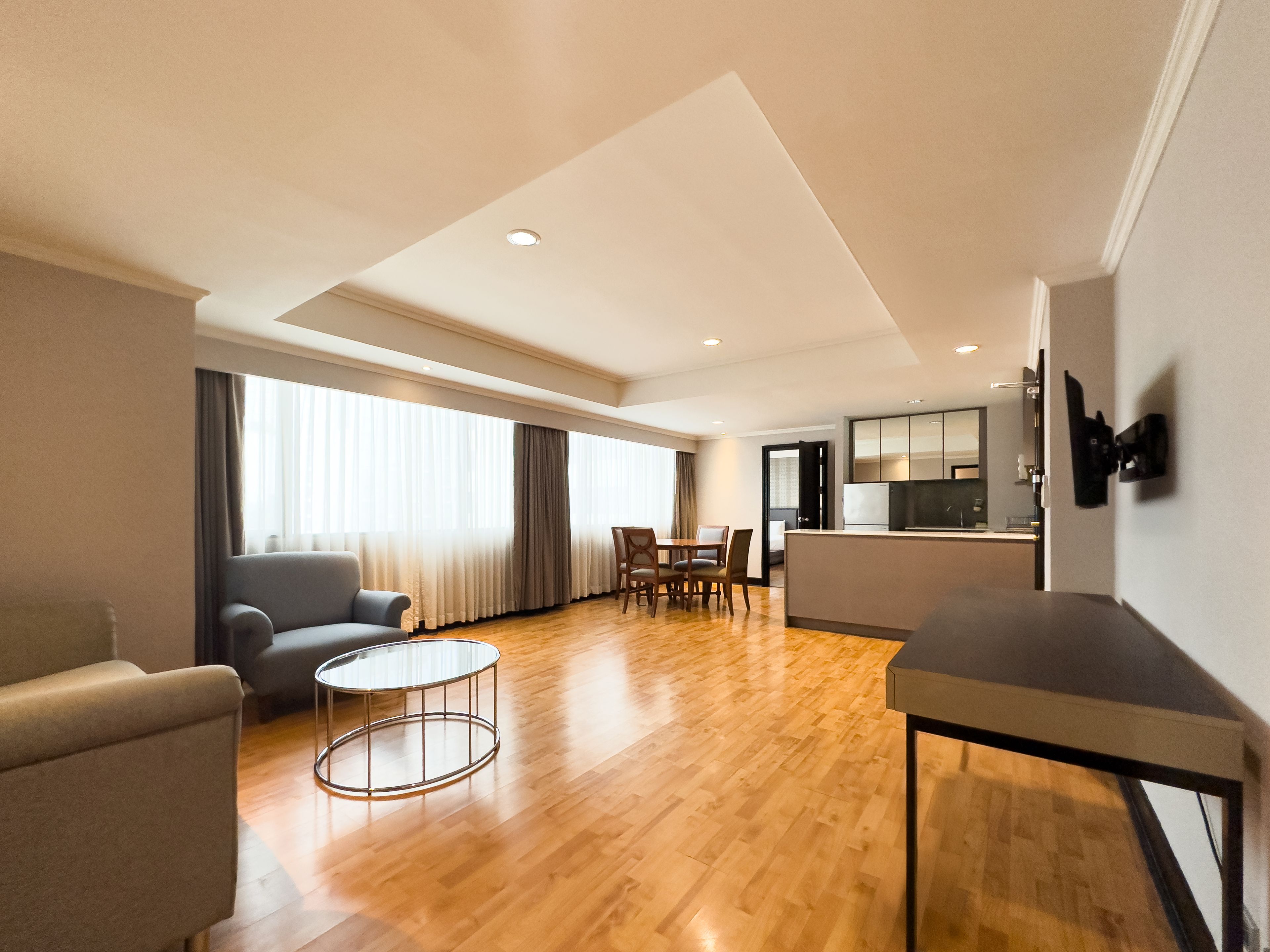 Une chambre d’hôtel moderne dotée d’un coin salon, d’un espace repas et d’une kitchenette.