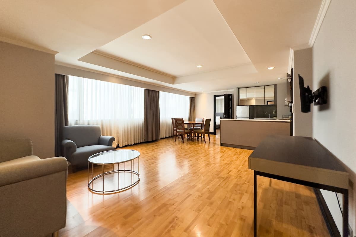 Una habitación de hotel moderna con sala de estar, una mesa de comedor y una cocina.