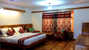 A bedroom with a wooden bed, a wooden desk, and a chair. - TIH Global Family Resort - Saboo - Leh (Leh)