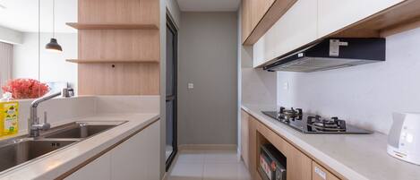 A modern kitchen with a built-in oven, a stove, and a sink.
