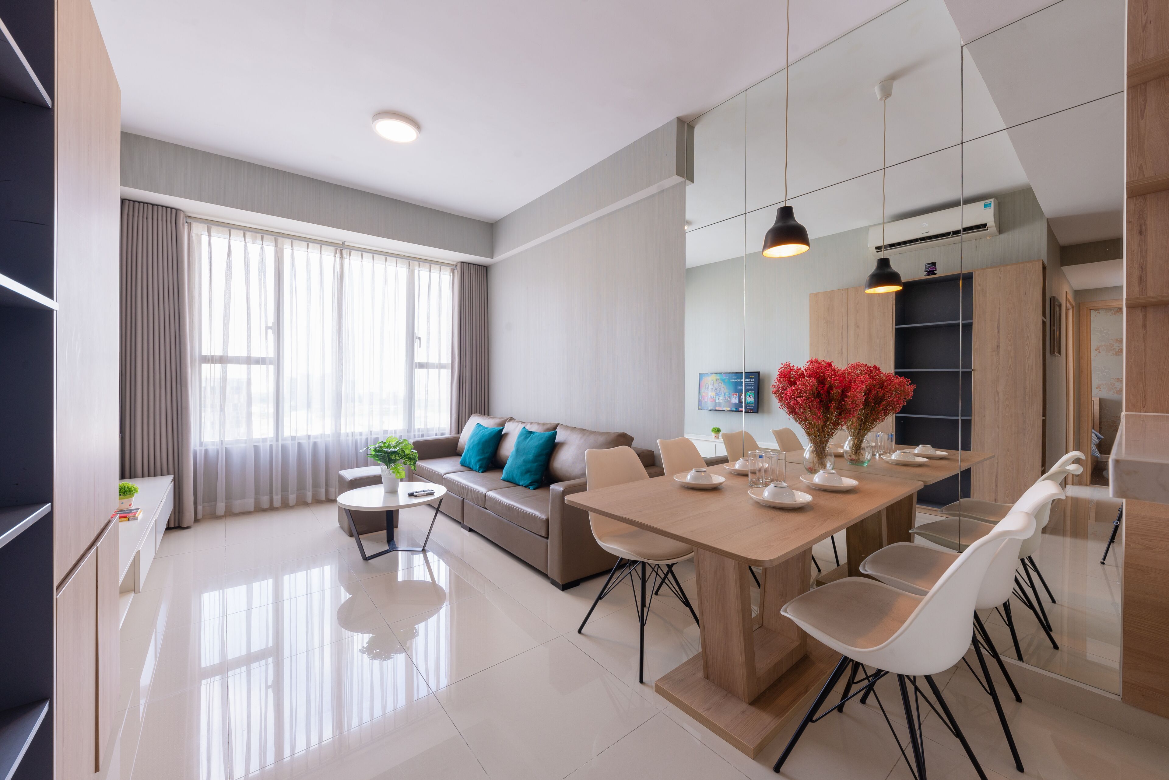 A modern living room with a sofa, coffee table, and dining area with chairs.