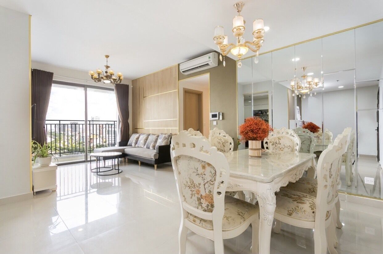 A modern living room with a dining table, chairs, and a chandelier.