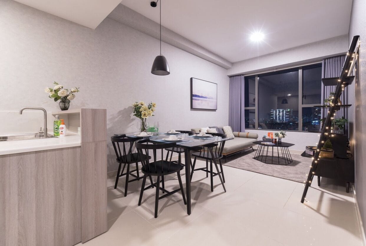 Un soggiorno moderno con zona pranzo, ampie finestre e vista sulla città.