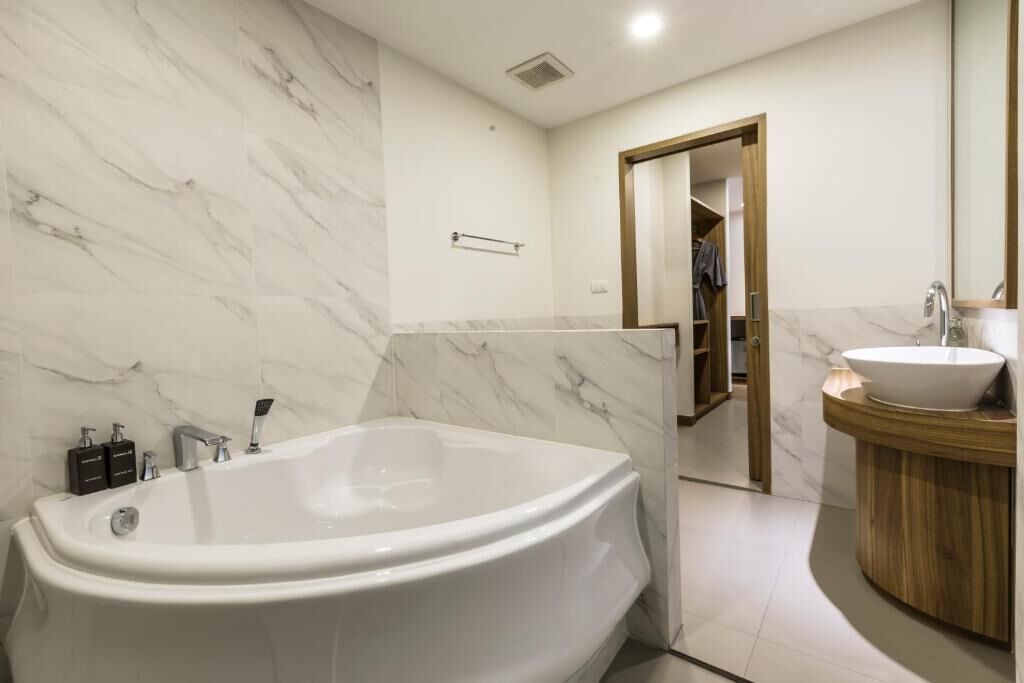 A modern bathroom with a freestanding bathtub, a vanity with a sink, and a mirror.